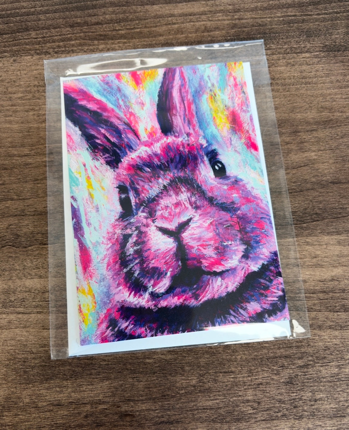 Colorful pink rabbit painting on a greeting card in a clear package