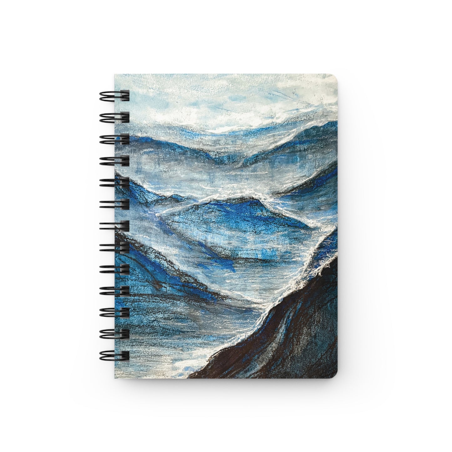 A spiral notebook with a abstract charcoal drawing with ethereal white and blue gouache accents, depicting a misty mountainous landscape.