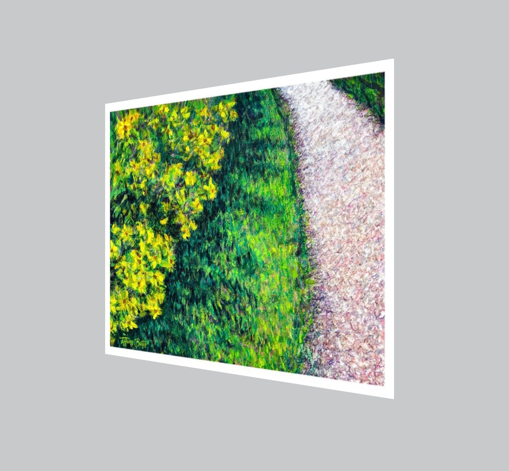 Angled view of a Fine art print of a painting of a wildflower field with yellow flowers and bright green grass and a path wrapping around.