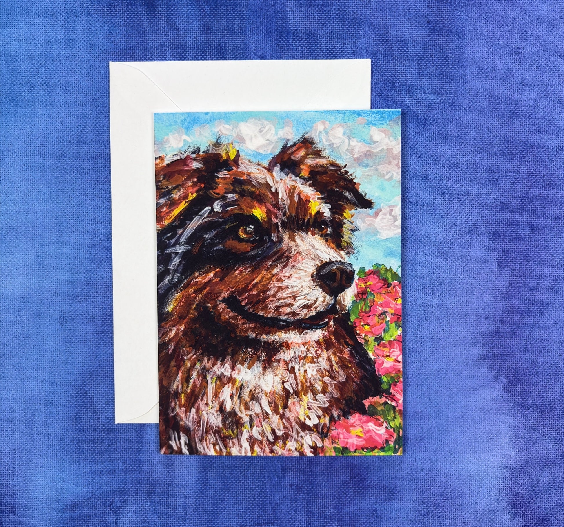 Greeting card with an Australian shepherd, Aussie, dog painting with flowers on a blue background