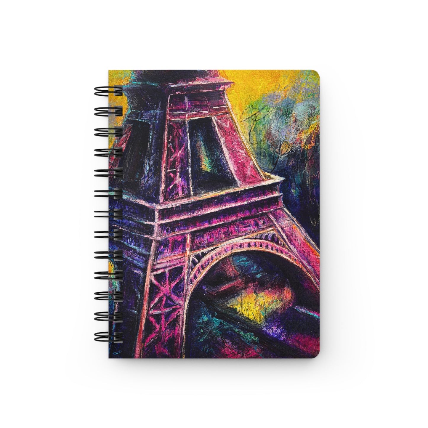 A spiral notebook with a colorful artistic cover featuring the Eiffel Tower with vibrant pinks and yellows and purples.