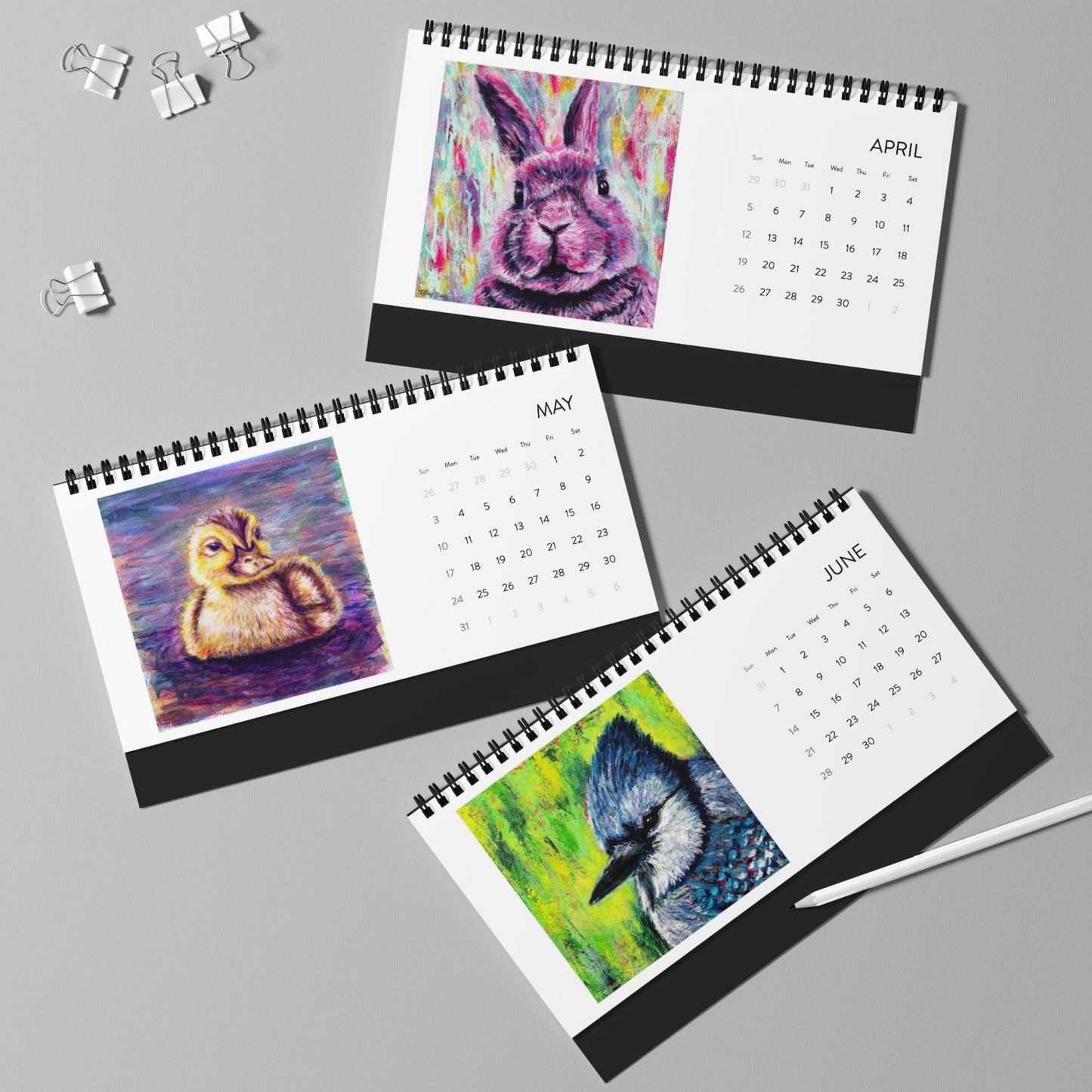 Three spiral-bound calendars showing April, May, and June with animal illustrations on a gray background.