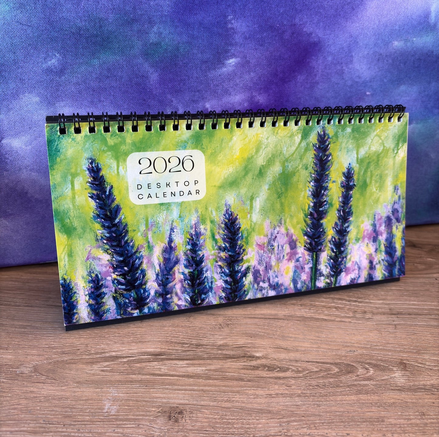 2026 desktop calendar with lavender design on a wooden surface and purple background