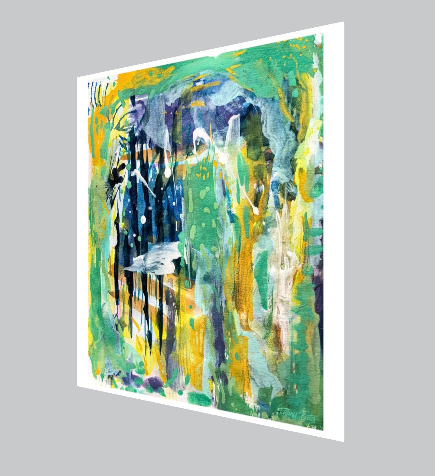 An angled view of an abstract fine art print of a gouache painting featuring layers of greens, deep blue stripes, and warm golden-yellow accents with white splatters.