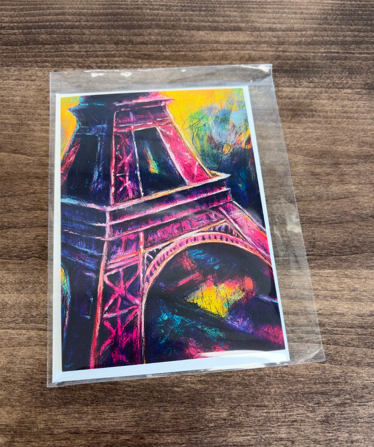 Colorful vibrant Eiffel Tower painting with pinks and yellows and purple on a blue textured background
